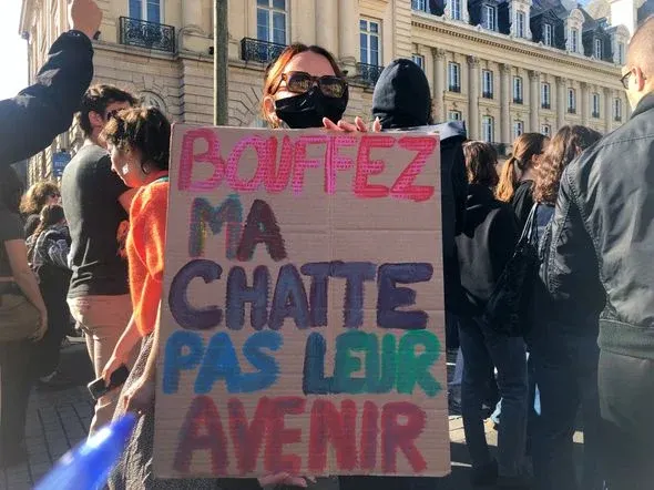 Pancarte en carton : « Bouffez ma chatte pas leur avenir »